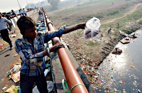 An Indian boy throws domestic garbage in...An Indian boy throws